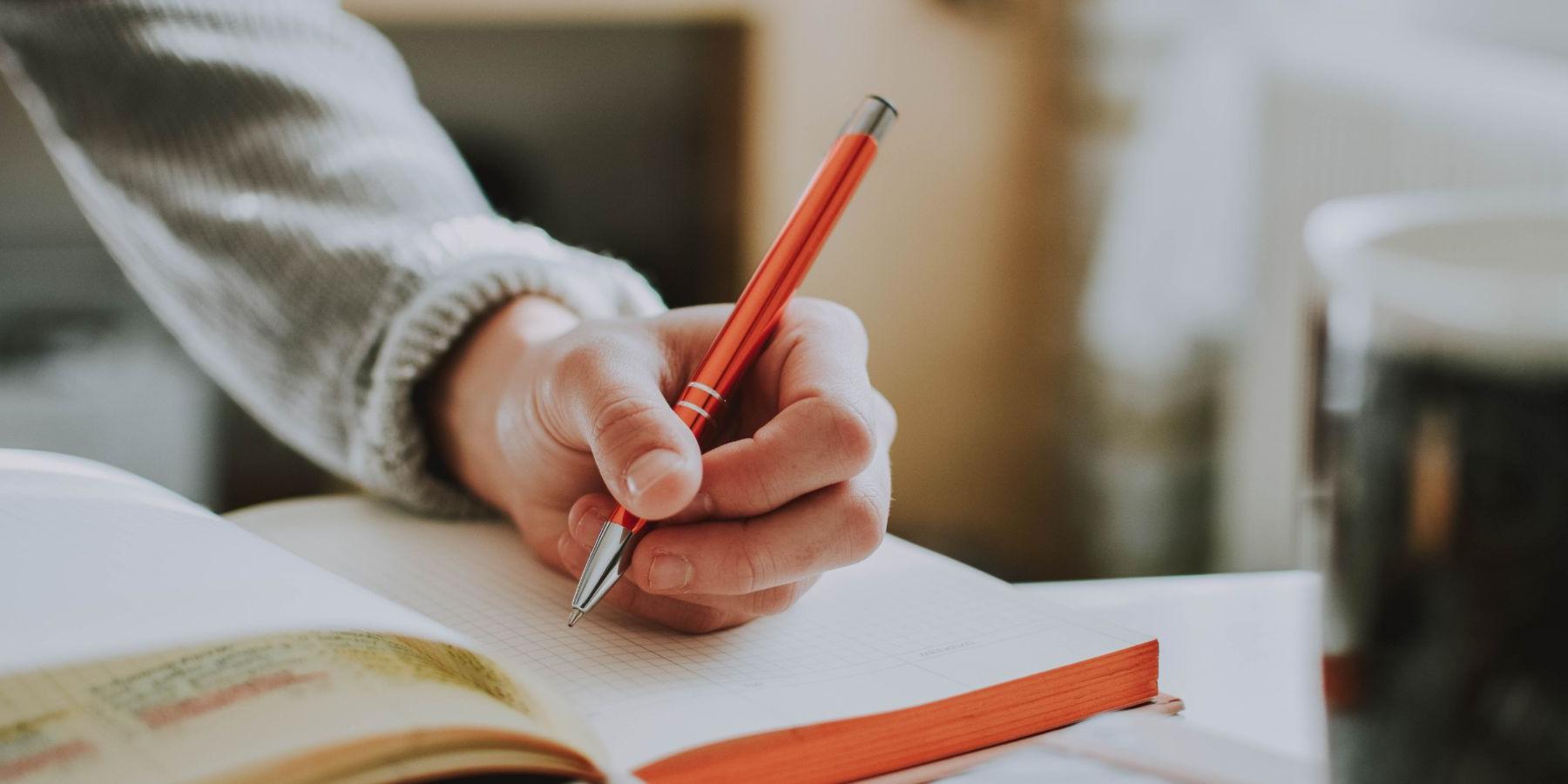 Person writing in a notebook.